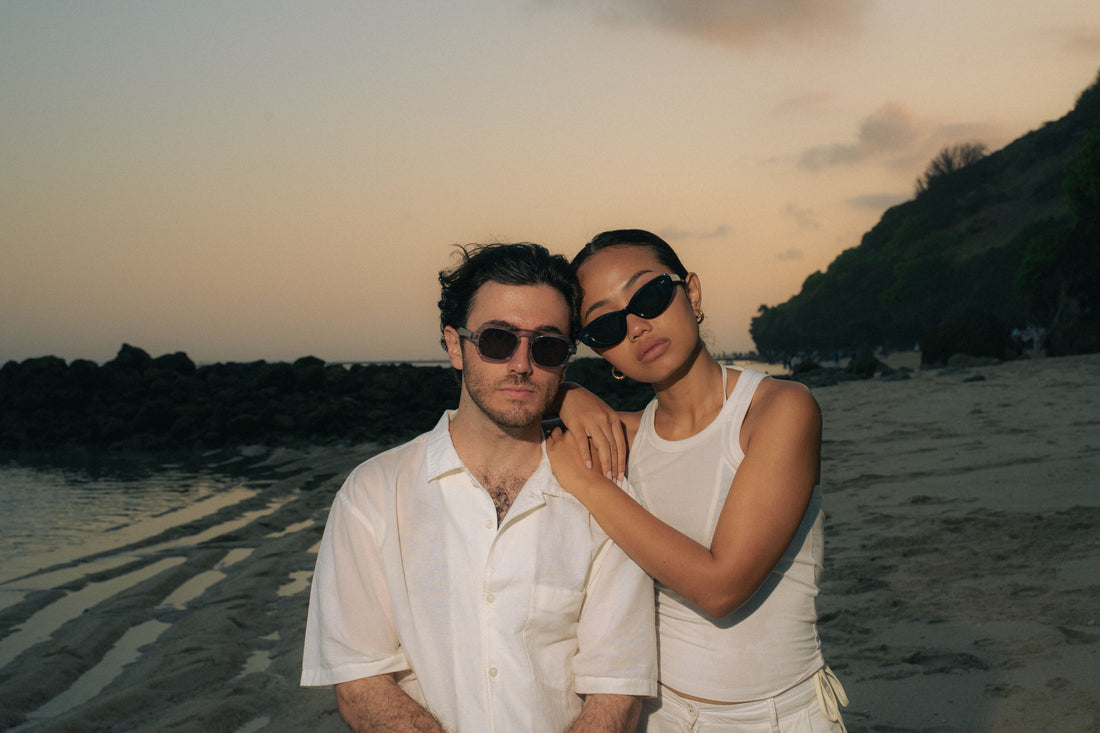 Couple wearing Maison Mata sunglasses on a Bali beach at sunset