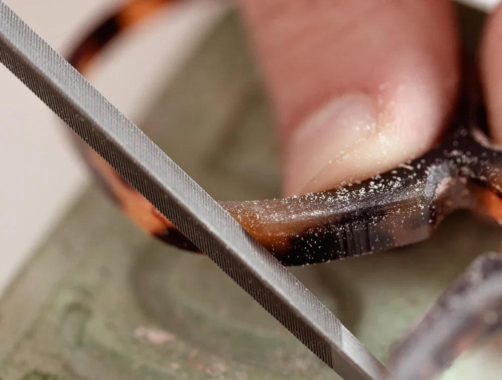 Artisan hand-filing a tortoise acetate frame in the Maison Mata workshop