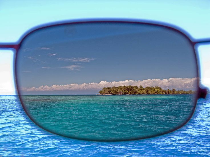Maison Mata Vorführung eines polarisierten Sonnenglases, das die Blendung über dem tropischen Meer und einer Insel auf Bali reduziert – Augenoptiker auf Bali.