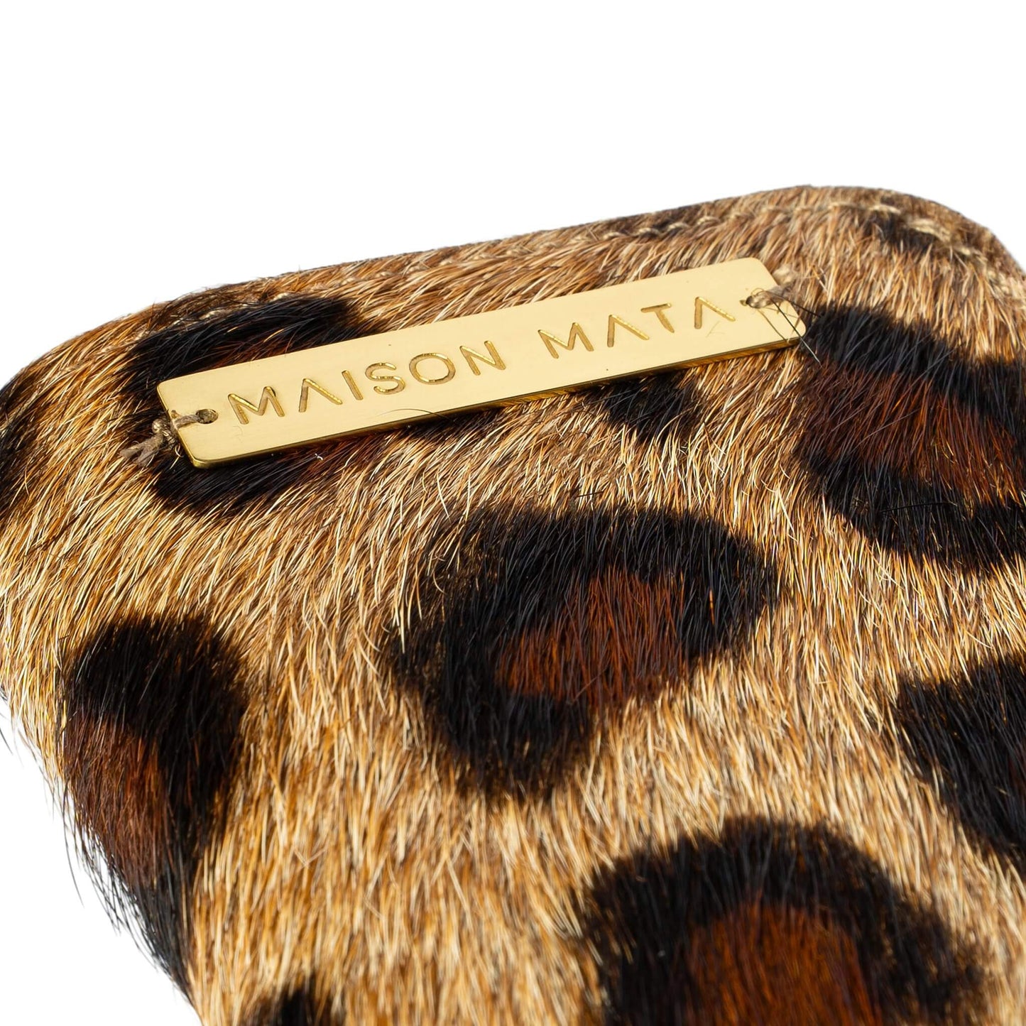 Engraved brass Maison Mata plate on the brown leopard softcase