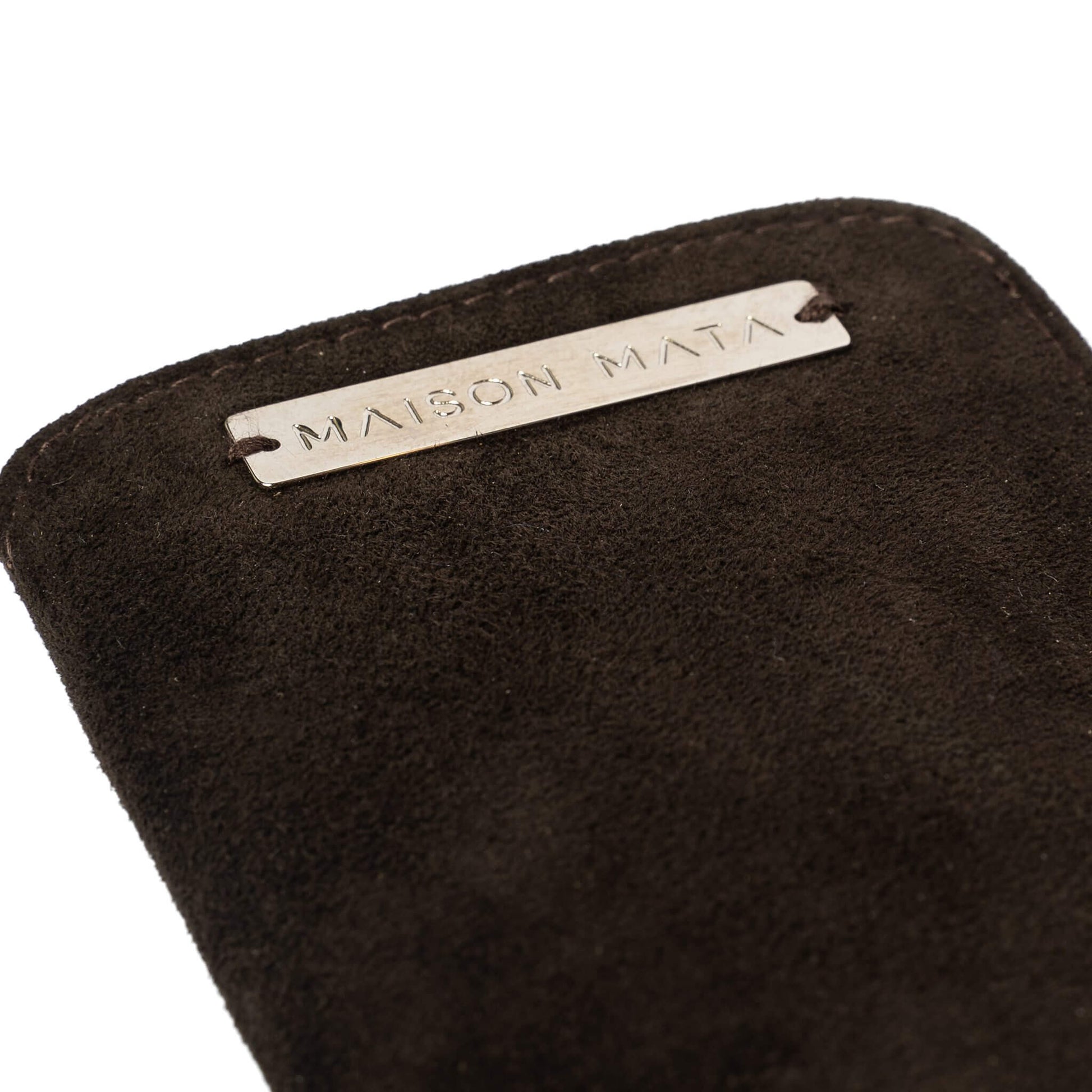Engraved silver Maison Mata plate on the dark brown suede softcase