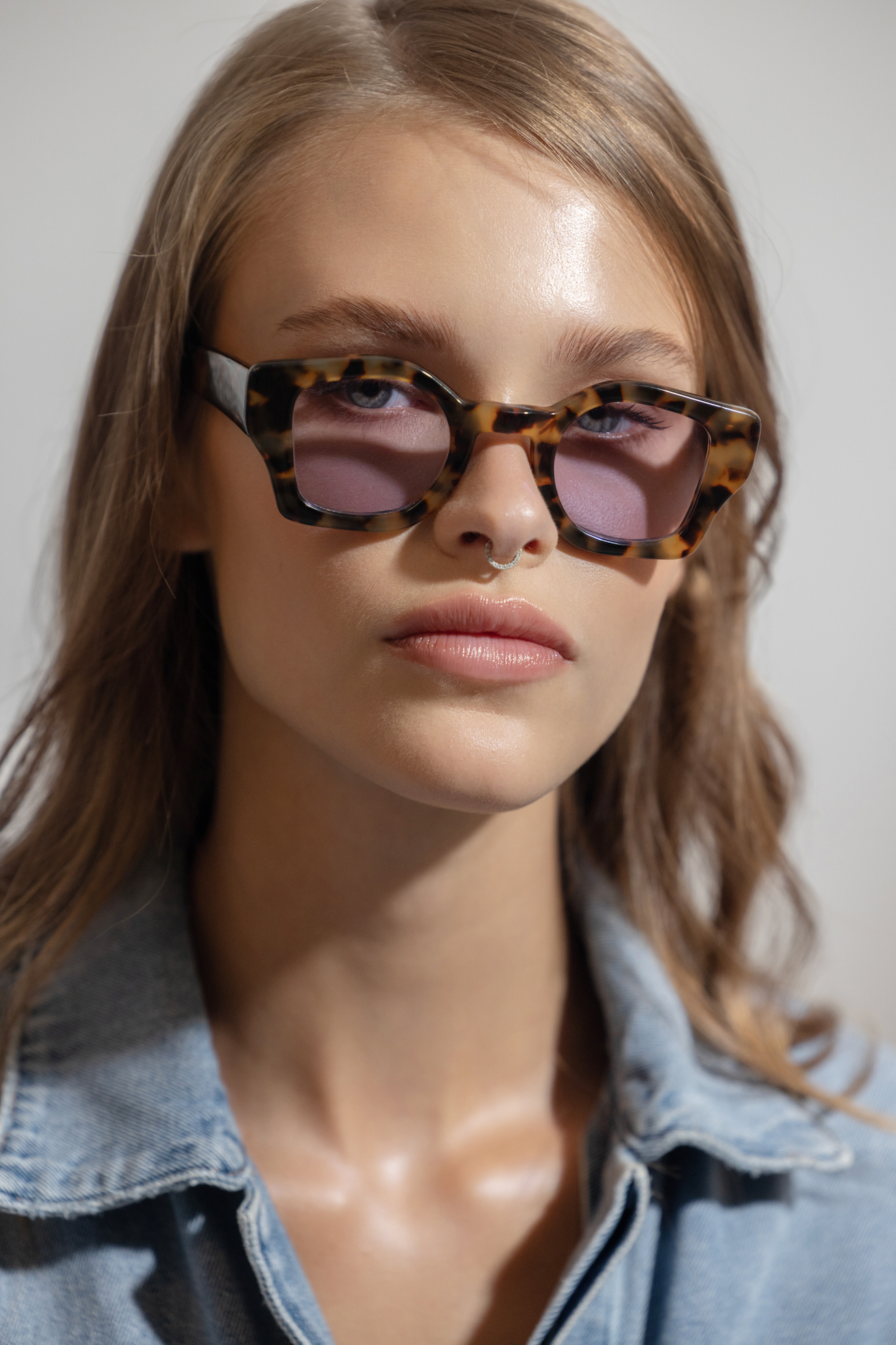Artisanal handmade polarized sunglasses showcased on a woman at the beach in Uluwatu in Bali guided by optometrists.