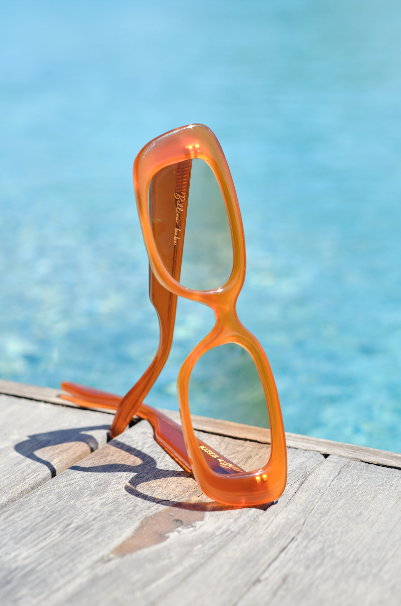 Orange rectangular acetate sunglasses fitted by opticians in Sanur in Bali for bright modern summer style.