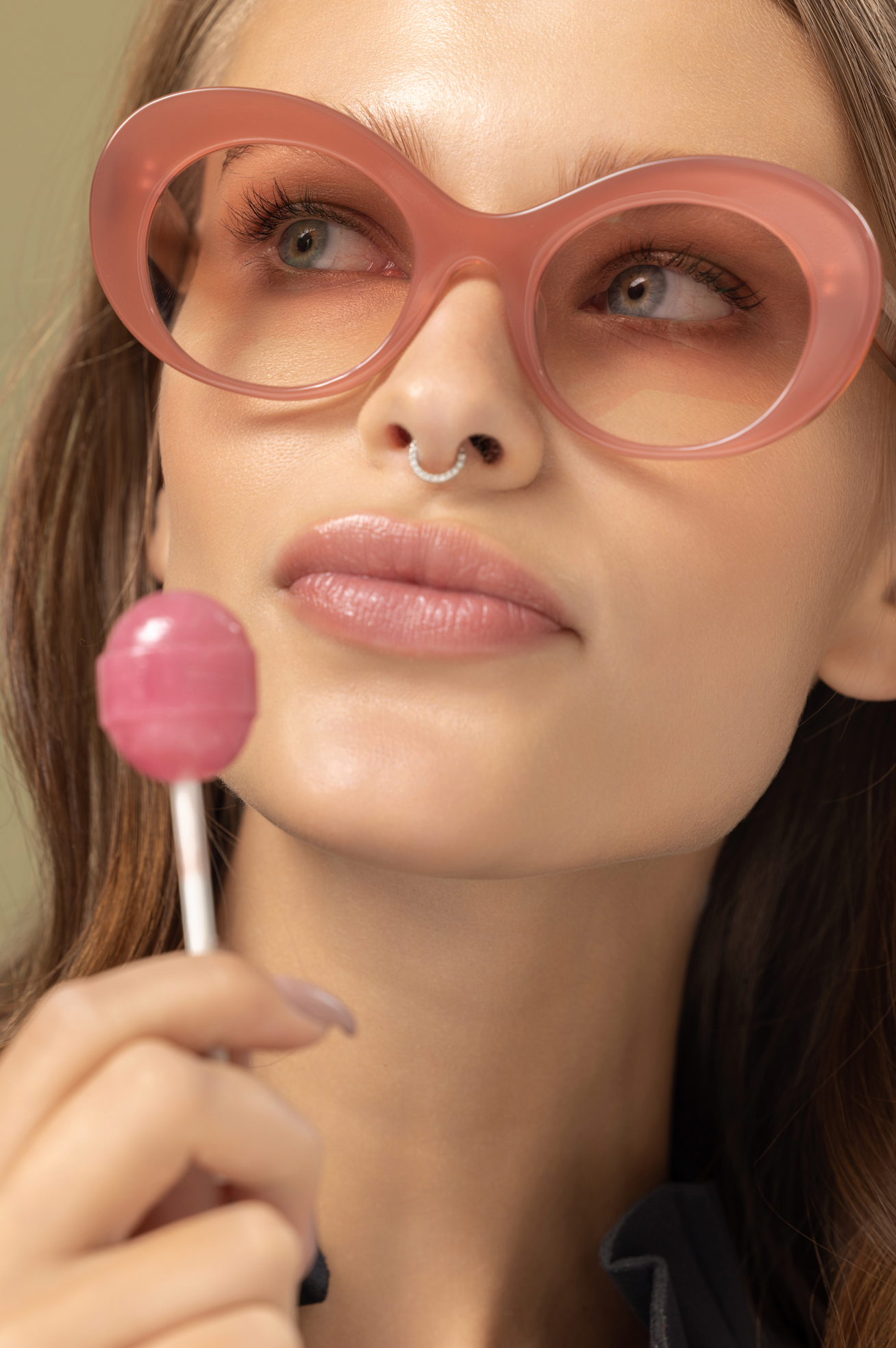 Pink lightly tinted sunglasses seen on a woman in a serene Bali villa setting refined by Maison Mata opticians.