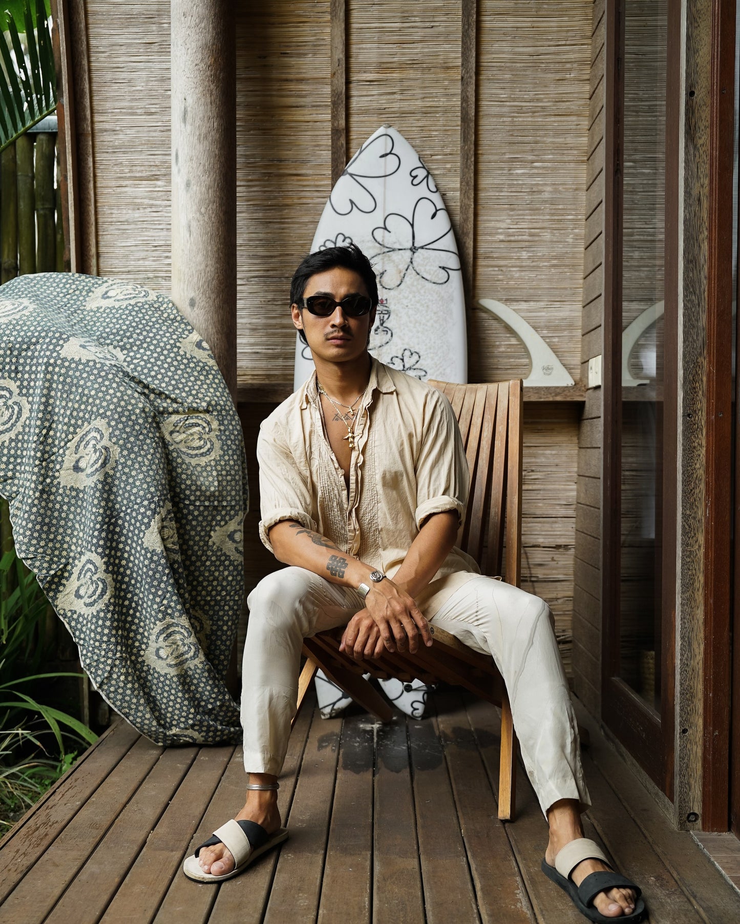 Man in Bali Blue Midnight Sky sunglasses seated on a wooden terrace in Bali