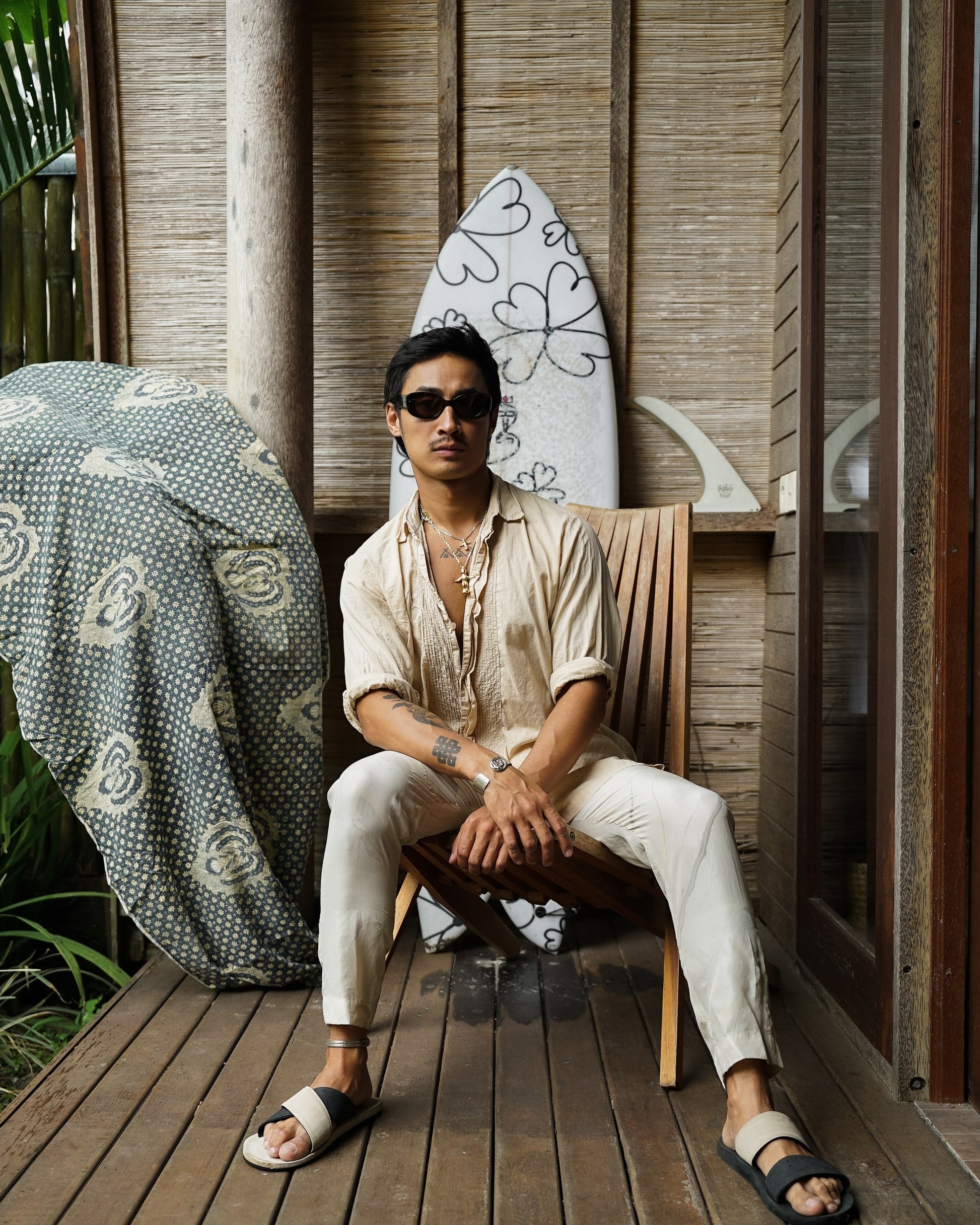 Man in Bali Blue Midnight Sky sunglasses seated on a wooden terrace in Bali