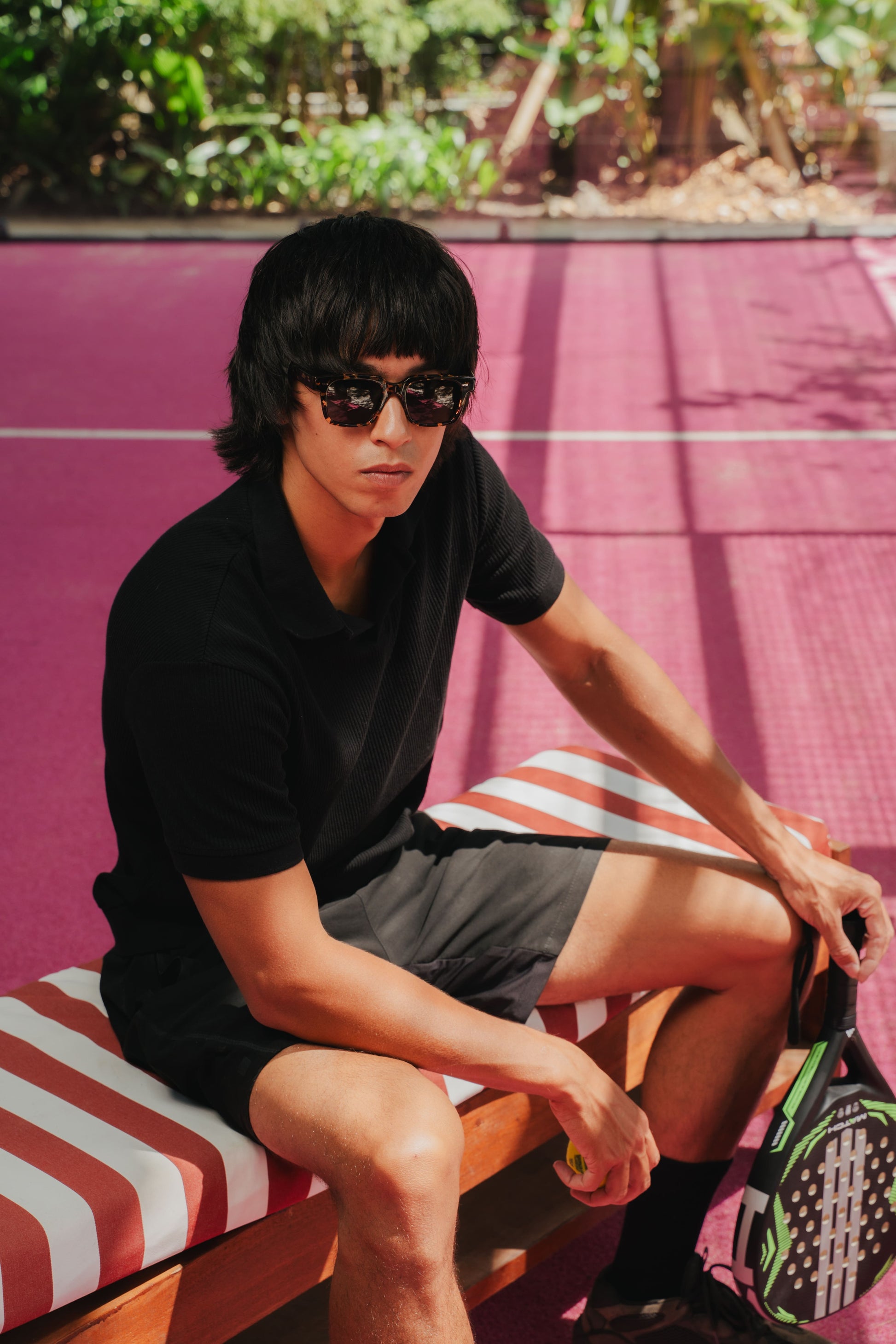 Man wearing Borneo Bliss Black Sun rectangular sunglasses with a padel racket in Bali