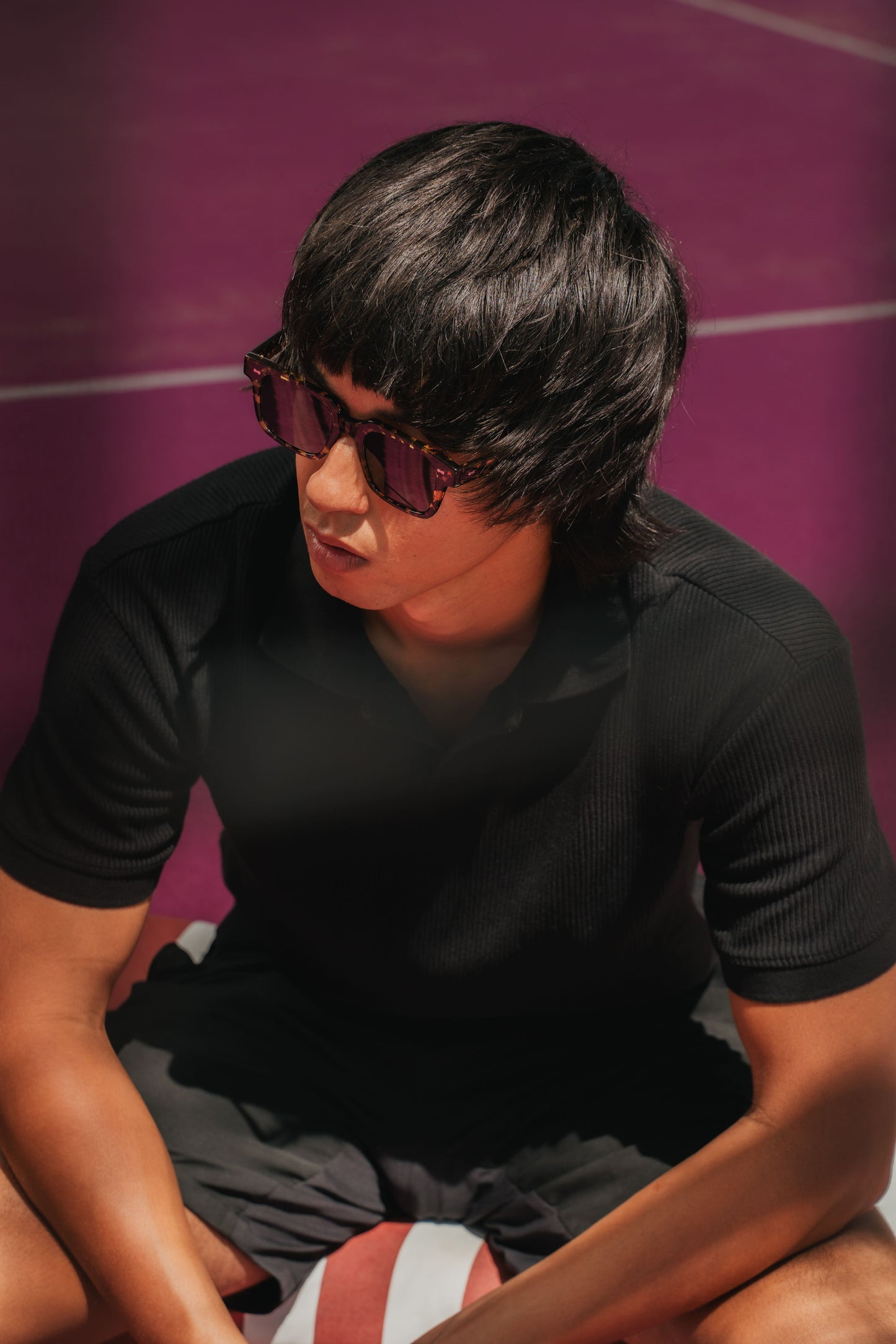 Close-up of Borneo Bliss Black Sun acetate sunglasses on a Bali padel court Maison Mata