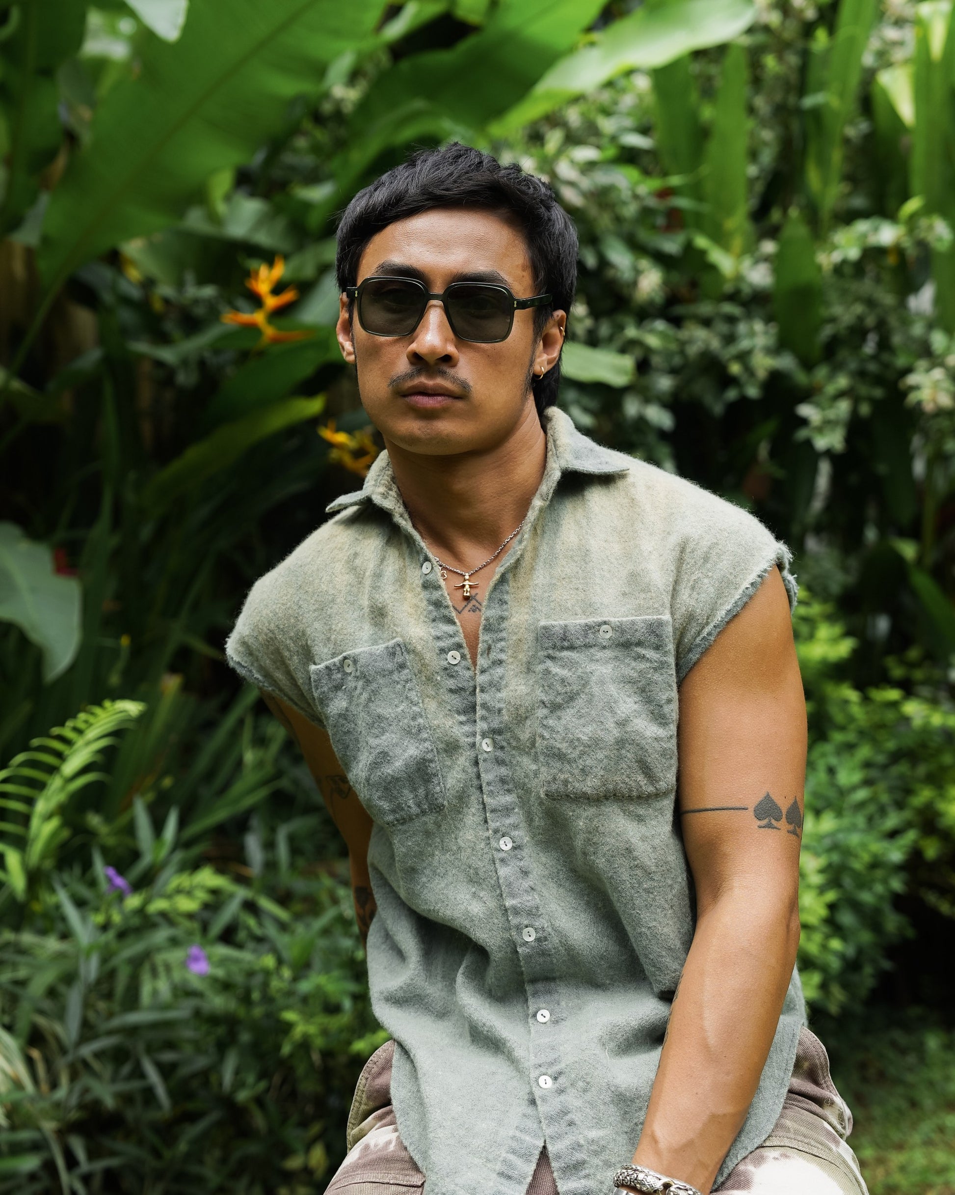 Man in Gili Escape Olive Gove square sunglasses in a tropical Bali garden