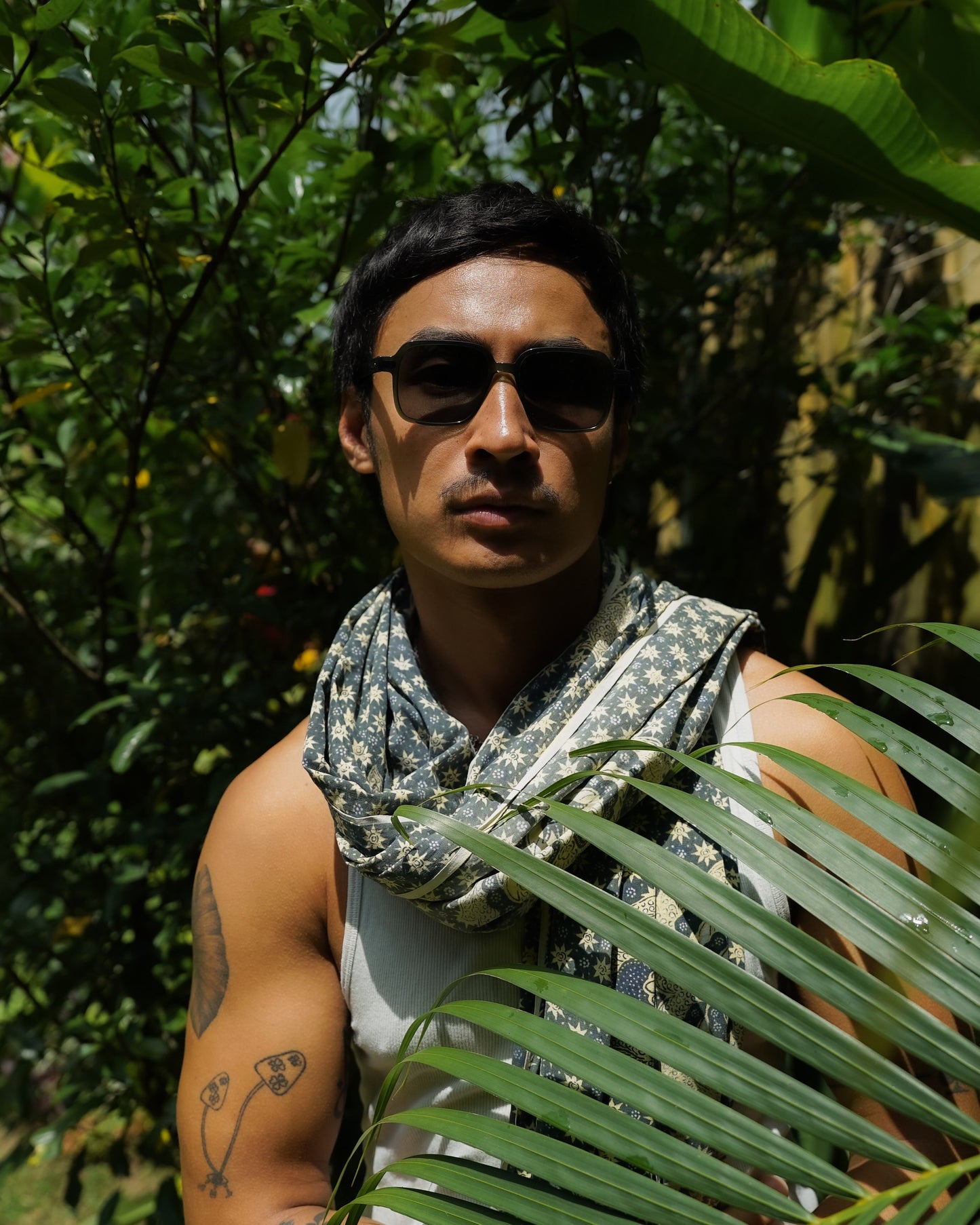 Man wearing Gili Escape Olive Gove olive square sunglasses and a scarf