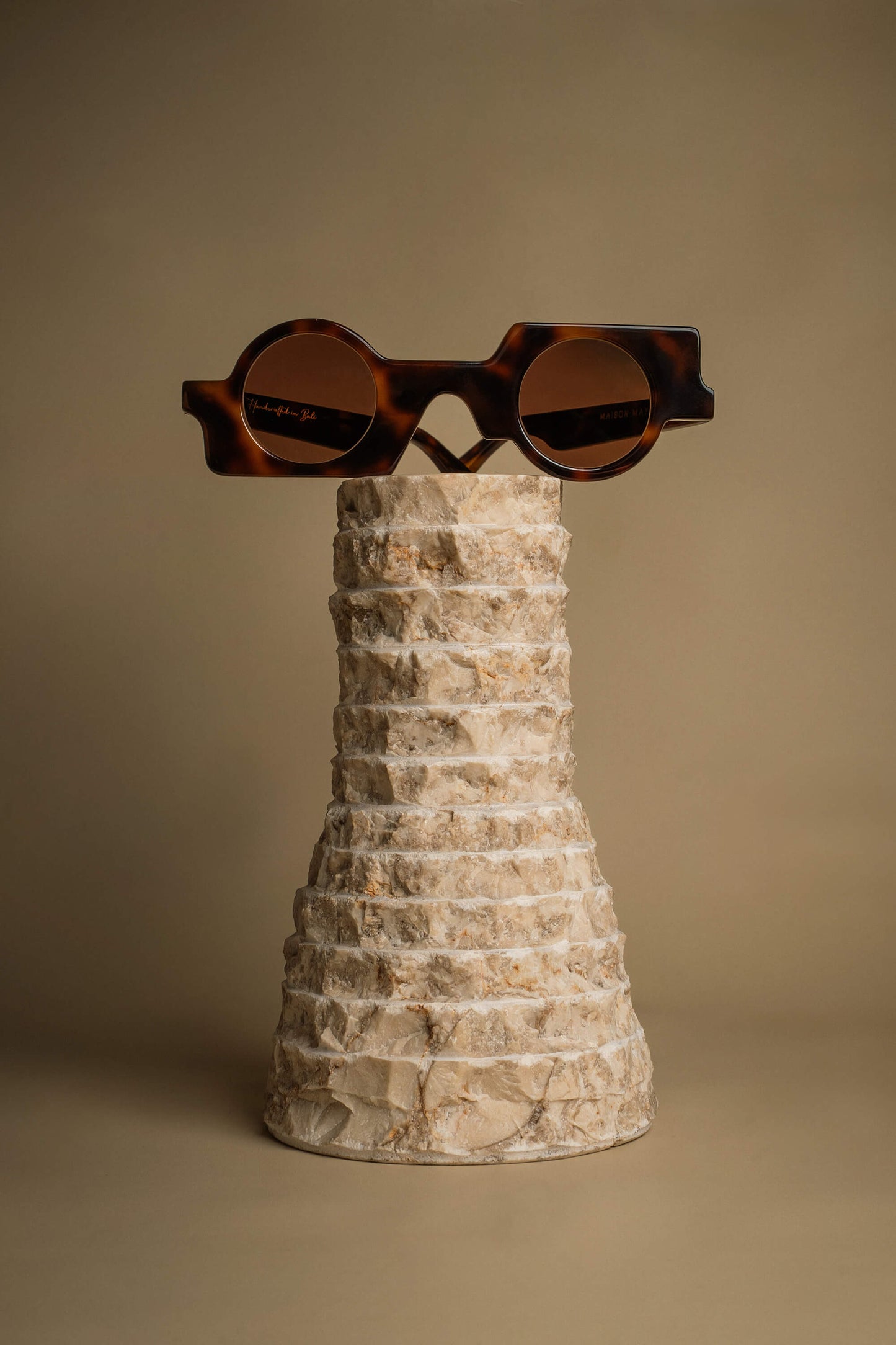 Maison Mata handmade tortoiseshell acetate geometric sunglasses with round lenses on a ceramic stand — lunettes de soleil géométriques acétate écaille verres ronds — kacamata geometris asetat tortoise lensa bulat — gafas geométricas carey lentes redondas — Bali handmade eyewear