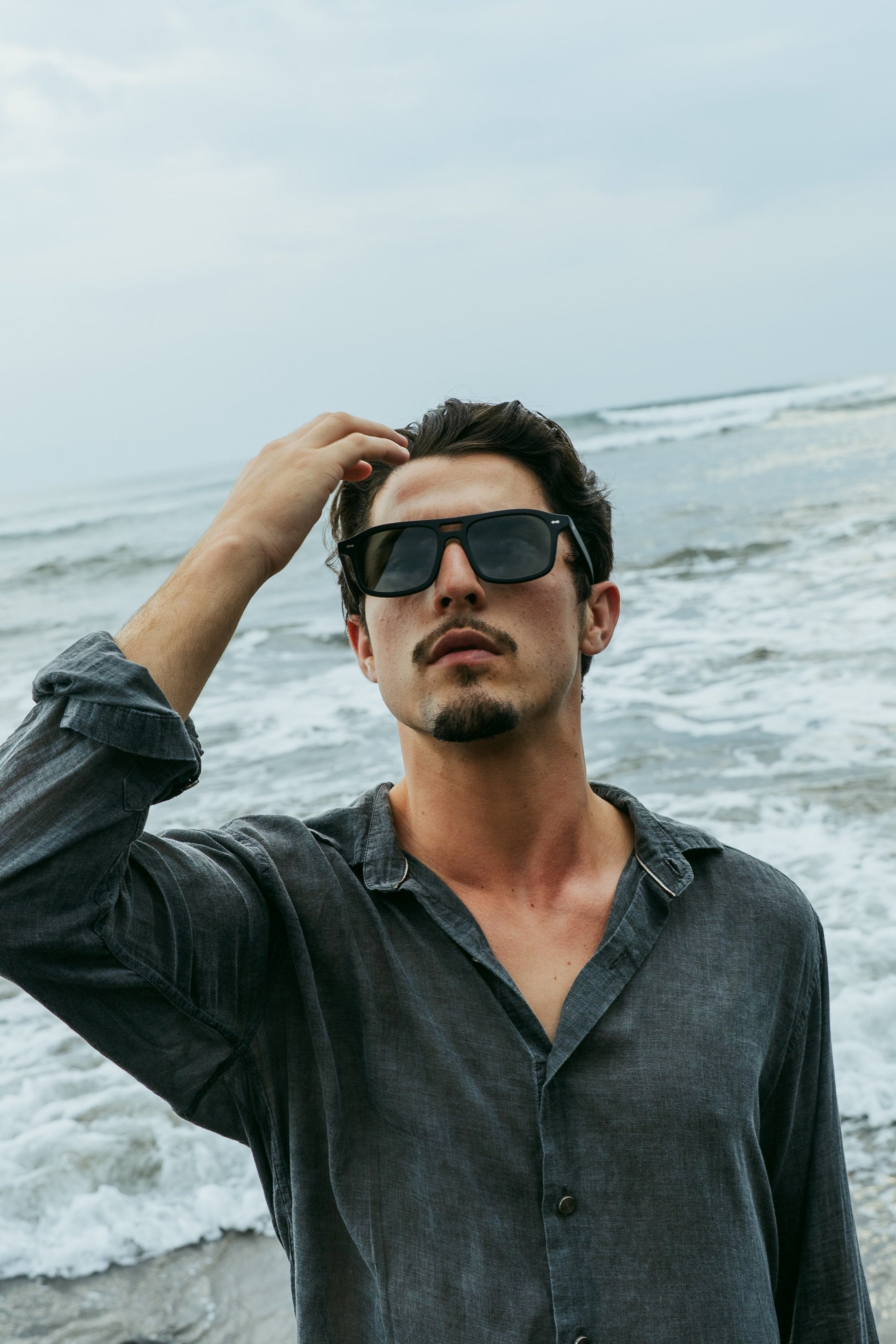 Man in Java Joy Velvet Noir sunglasses by the ocean in Bali