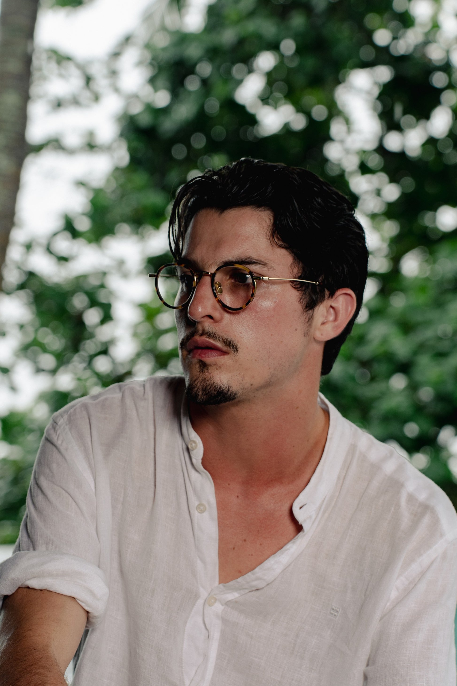 Man wearing Java Jungle Sunset Glow round optical frames in a Bali garden