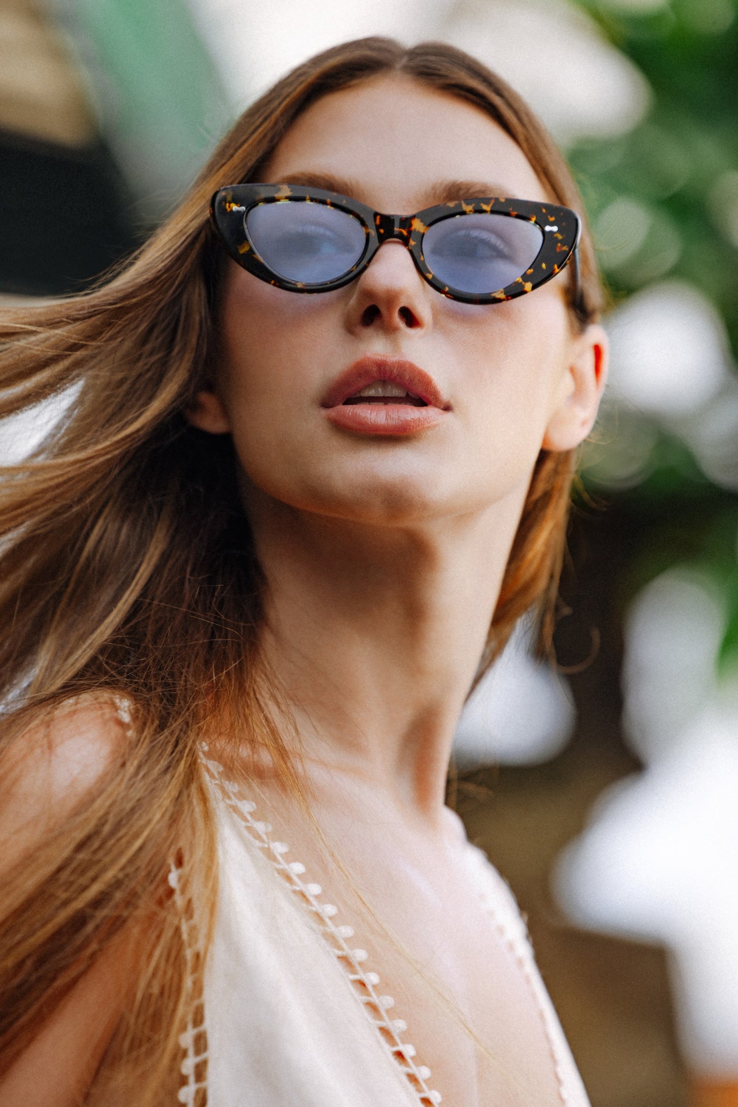 Woman wearing Lombok Luxe Black Sun cat-eye acetate sunglasses hair in the wind