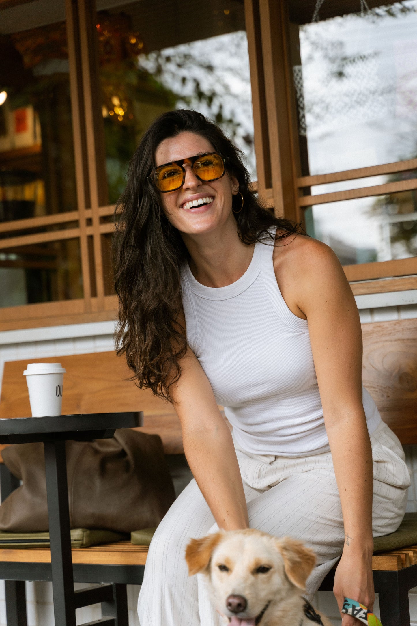Smiling woman wearing Luxe Co. Caramel Swirl acetate sunglasses with yellow lenses, Maison Mata Bali