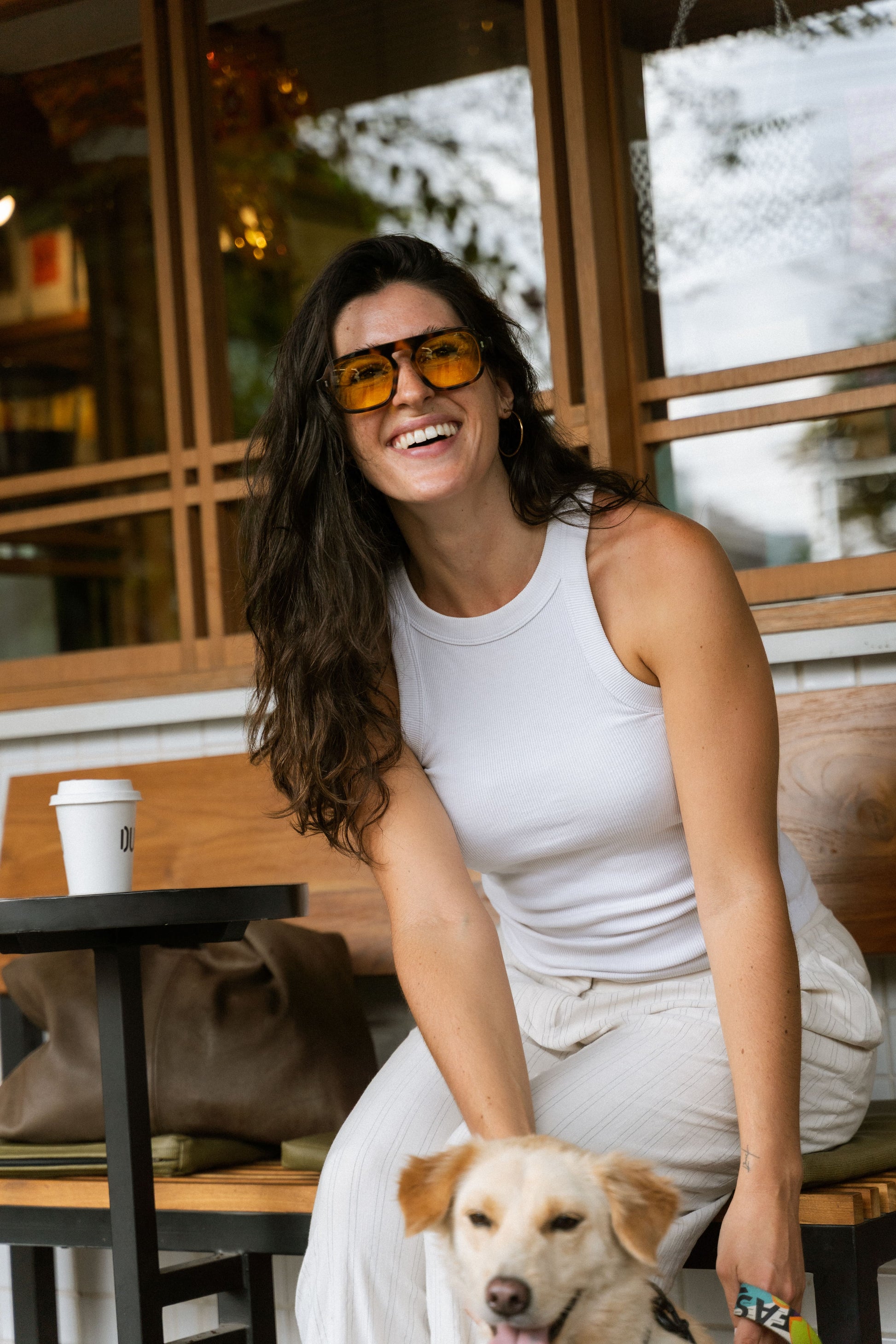 Smiling woman wearing Luxe Co. Caramel Swirl acetate sunglasses with yellow lenses, Maison Mata Bali