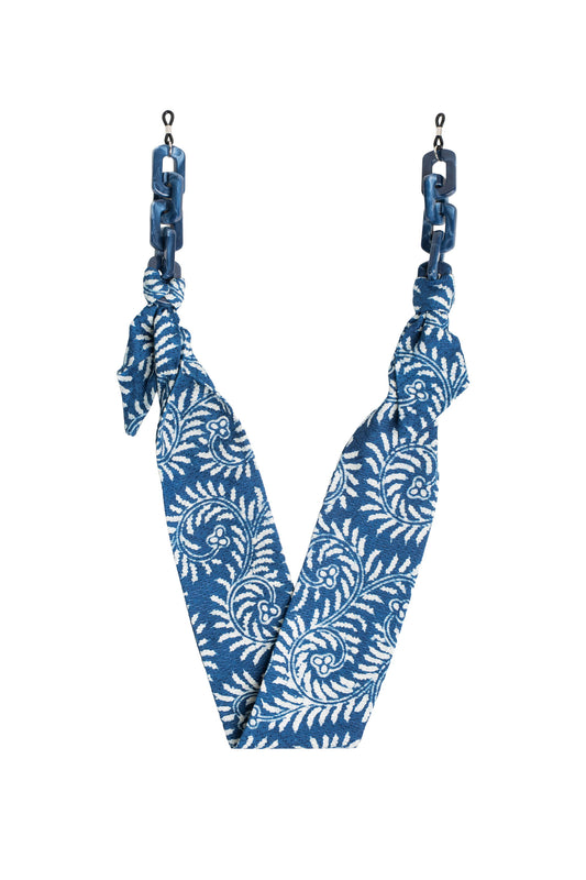 Rantai kacamata Maison Mata Maha Indigo Fern dari katun batik yang dicelup di Jawa, dirakit di Bali, tampak tergantung