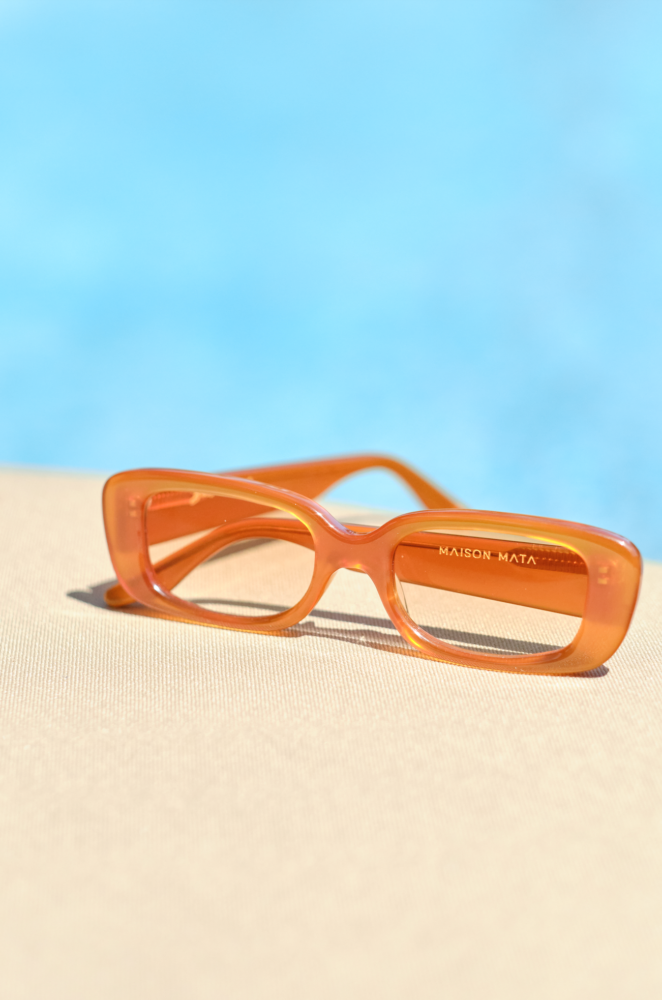 Rectangular orange polarized women’s sunglasses adjusted by optometrists in Uluwatu in Bali for bold fashion eyewear lovers.