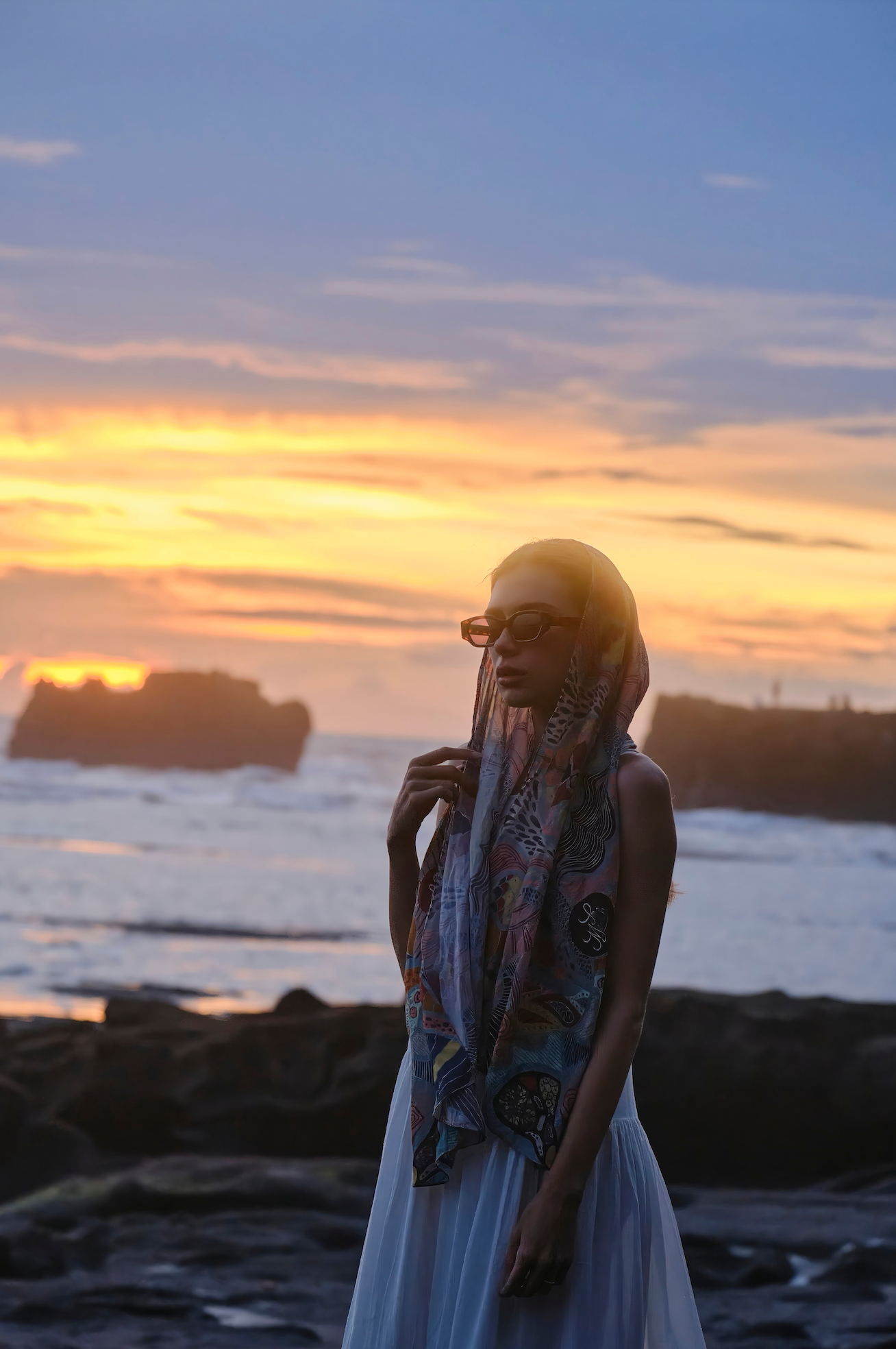 Artisanal polarized handmade sunglasses showcased on a woman at the beach in Uluwatu in Bali by Maison Mata opticians.